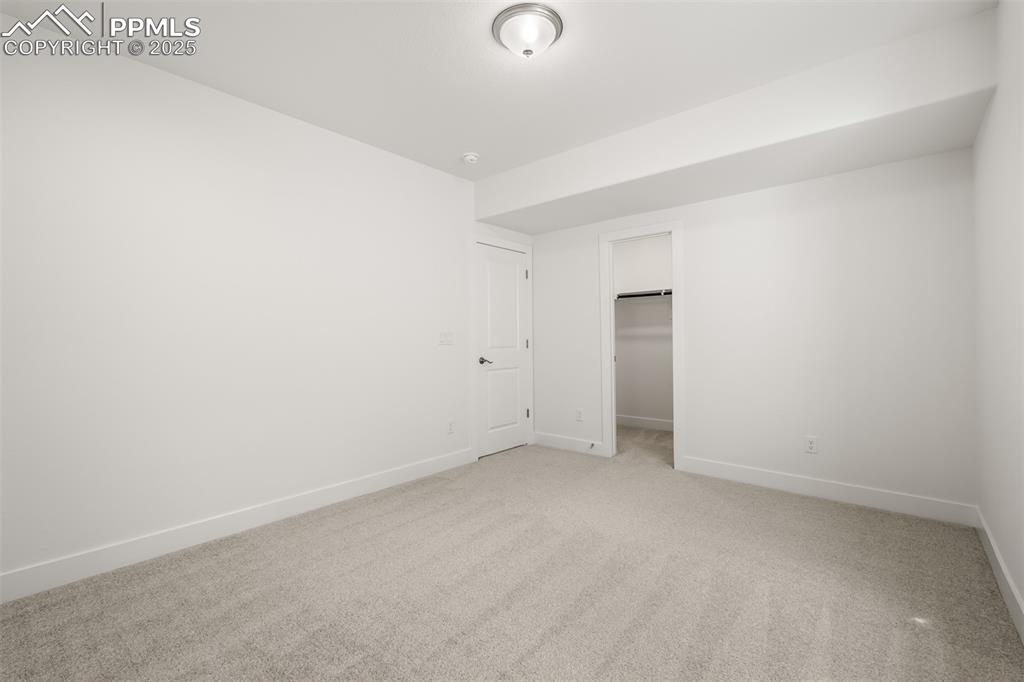 Image 44 of 46: Unfurnished bedroom with light colored carpet and a spacious closet