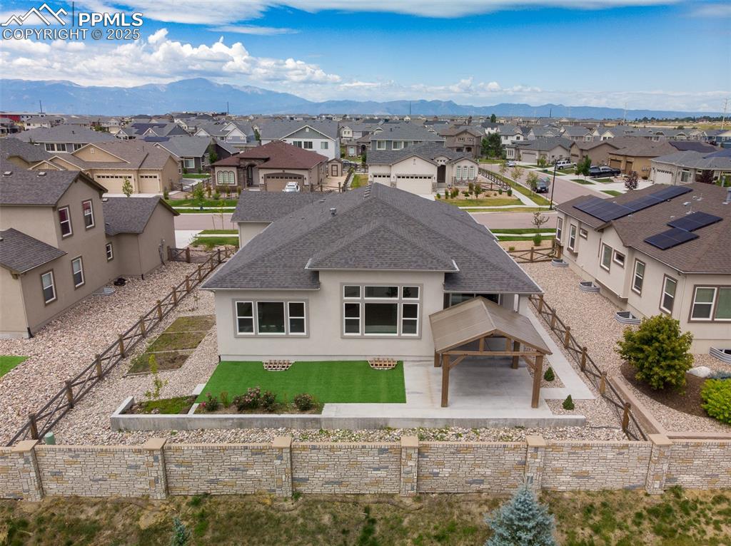 Image 5 of 46: Aerial view of residential area featuring a mountainous background