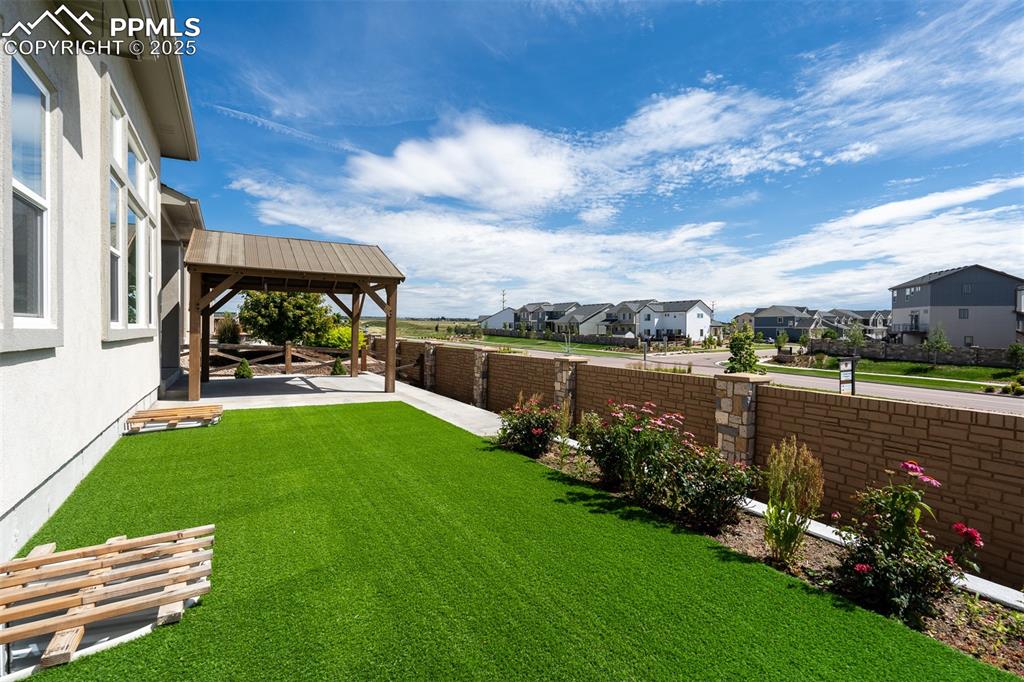 Image 9 of 46: Fenced backyard with a residential view, a gazebo, and a patio area
