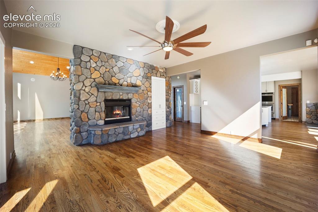 Image 13 of 40: Stone-faced fireplace with hearth and wood mantel