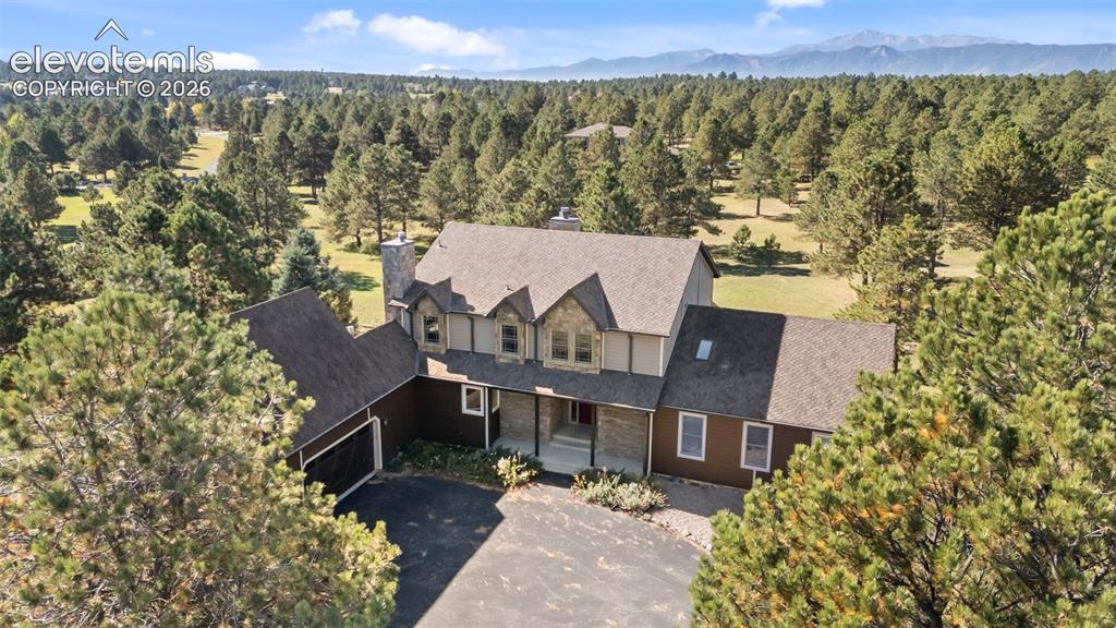 Image 2 of 40: Expansive property featuring a multi-level home with a stone chimney and do