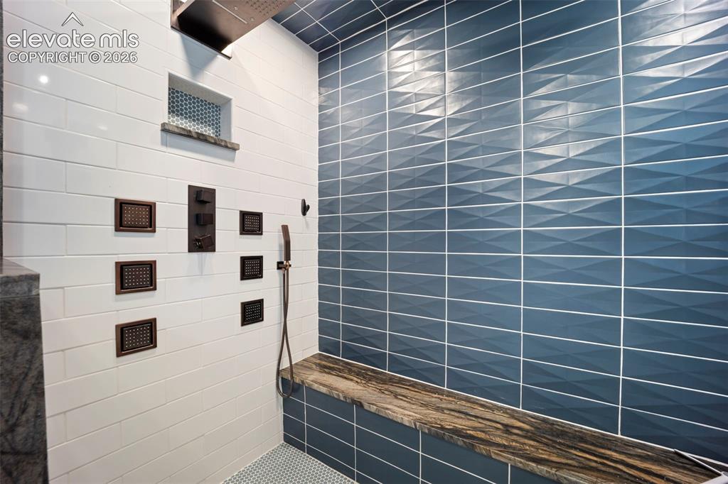 Image 21 of 40: Shower featuring a multi-function shower system with a rainfall showerhead,
