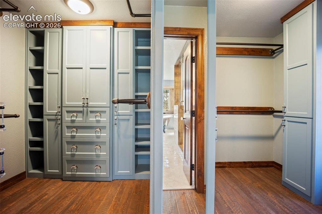 Image 22 of 40: Custom closet system featuring built-in cabinetry, shelving, and drawers
