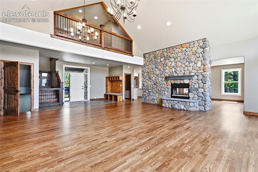 Image 3 of 40: Spacious open-concept living area featuring hardwood flooring, a prominent