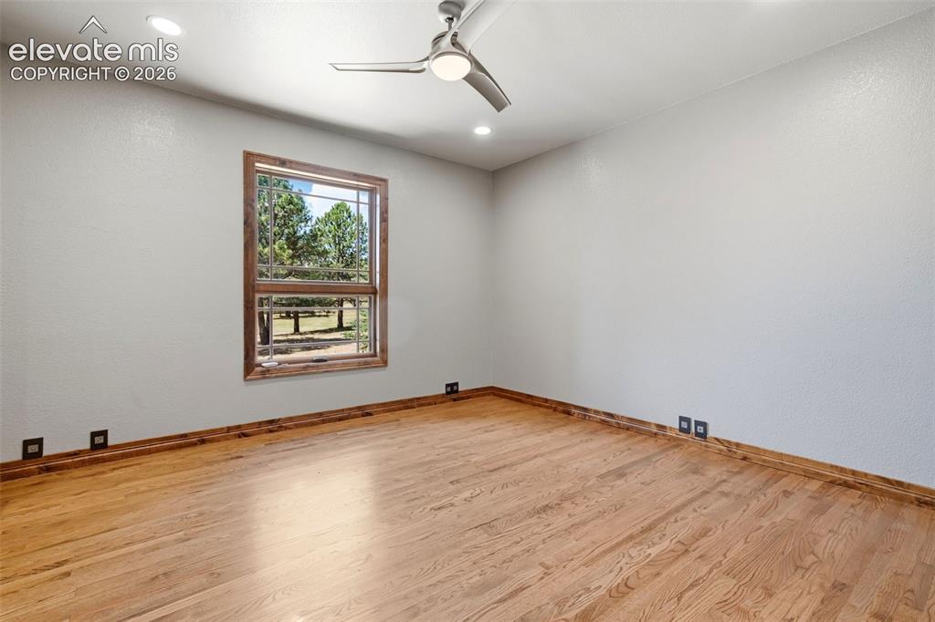 Image 31 of 40: Room featuring warm wood-finish flooring, a large window with natural wood
