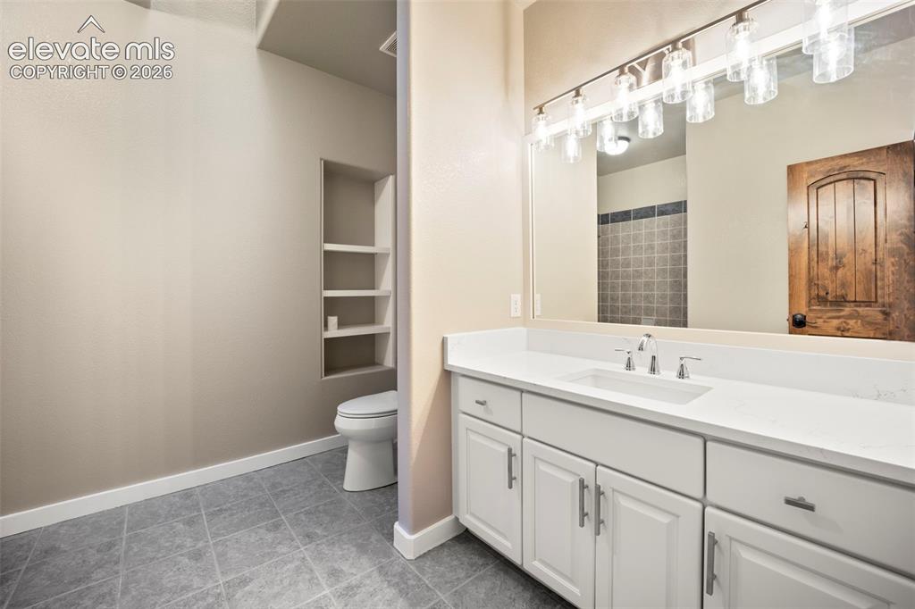 Image 35 of 40: Bathroom featuring a spacious vanity with an integrated sink, white cabinet