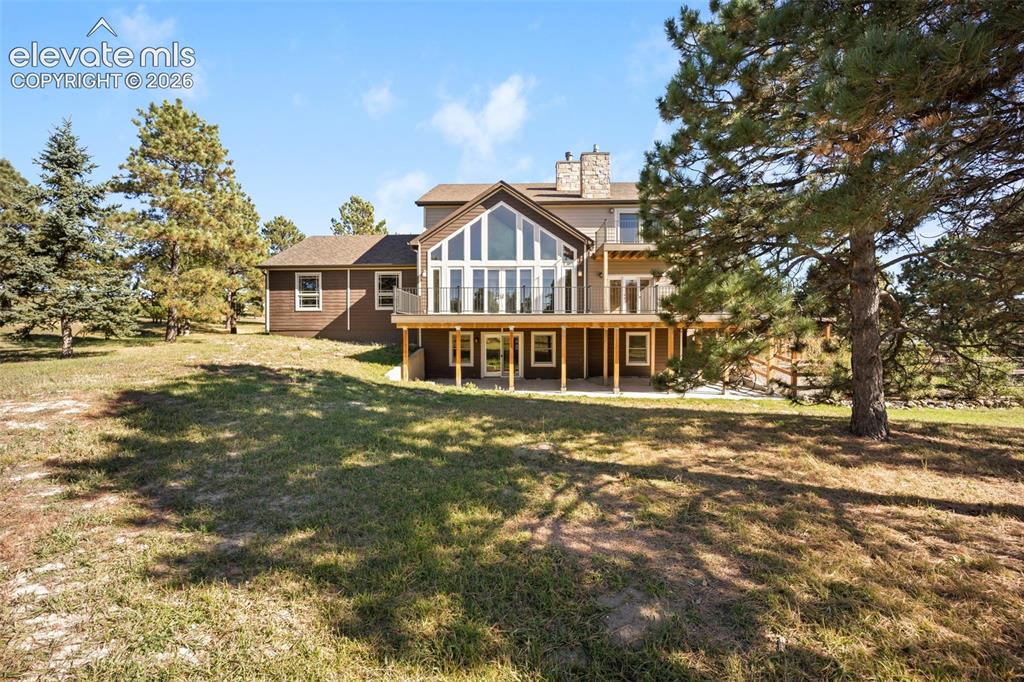 Image 38 of 40: Expansive backyard featuring a multi-level residence with a prominent gable