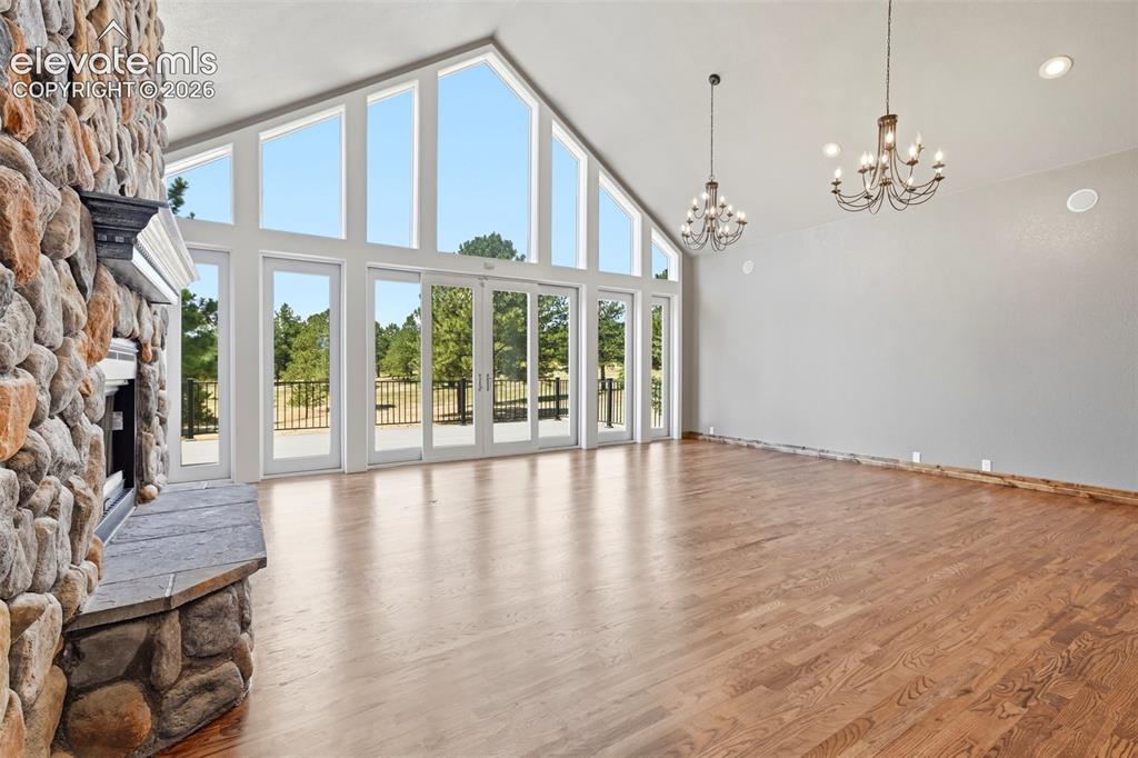 Image 5 of 40: Living area featuring a floor-to-ceiling stone fireplace with a stone heart