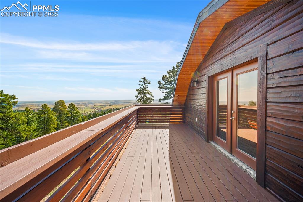 Image 30 of 50: Large deck with shelf railing overlooking beautiful wooded views of the cou