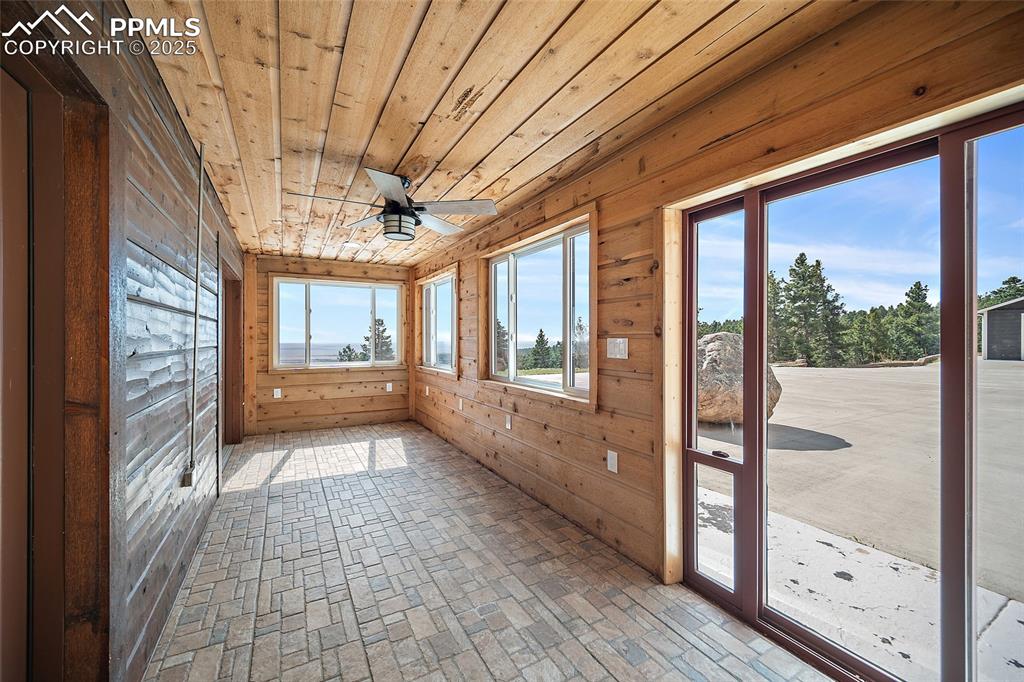 Image 35 of 50: Relaxing sunroom, beautifully lit with natural light from windows and slidi