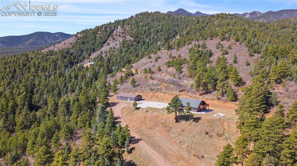 Image 42 of 50: Aerial side view of property with mountains