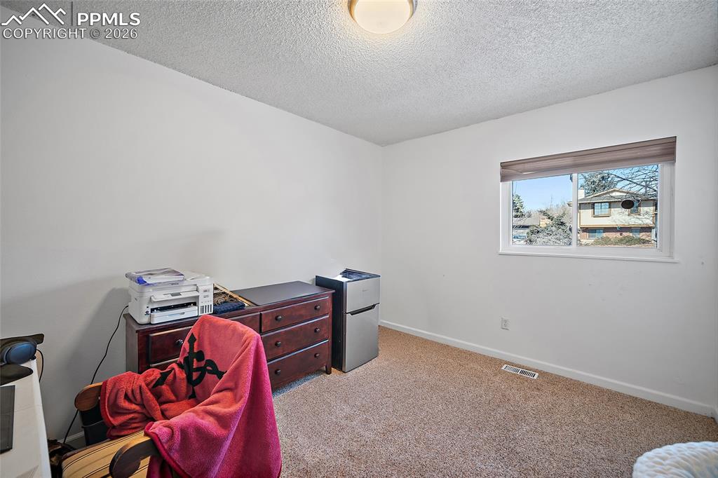 Image 21 of 37: Bedroom on the main level being used as an office. 
