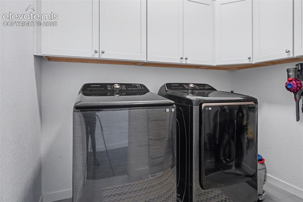 Image 19 of 41: Bathroom featuring double vanity, a tile shower, and light tile patterned f