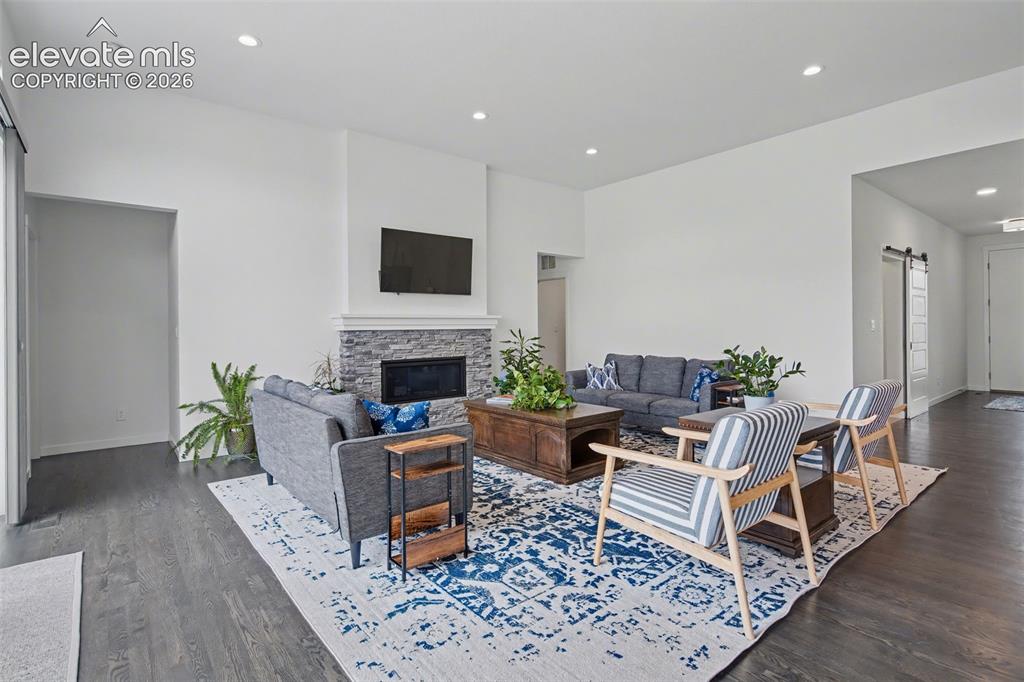 Image 7 of 41: Open-concept living space featuring wide-plank wood-finish flooring through