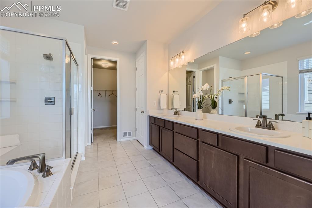 Image 19 of 50: Bathroom with vanity, tile patterned floors, and separate shower and tub