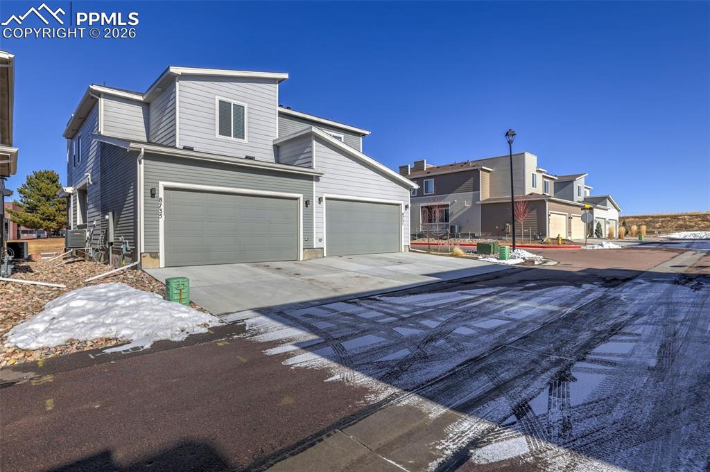 Image 28 of 28: View of front of house with concrete driveway and an attached garage