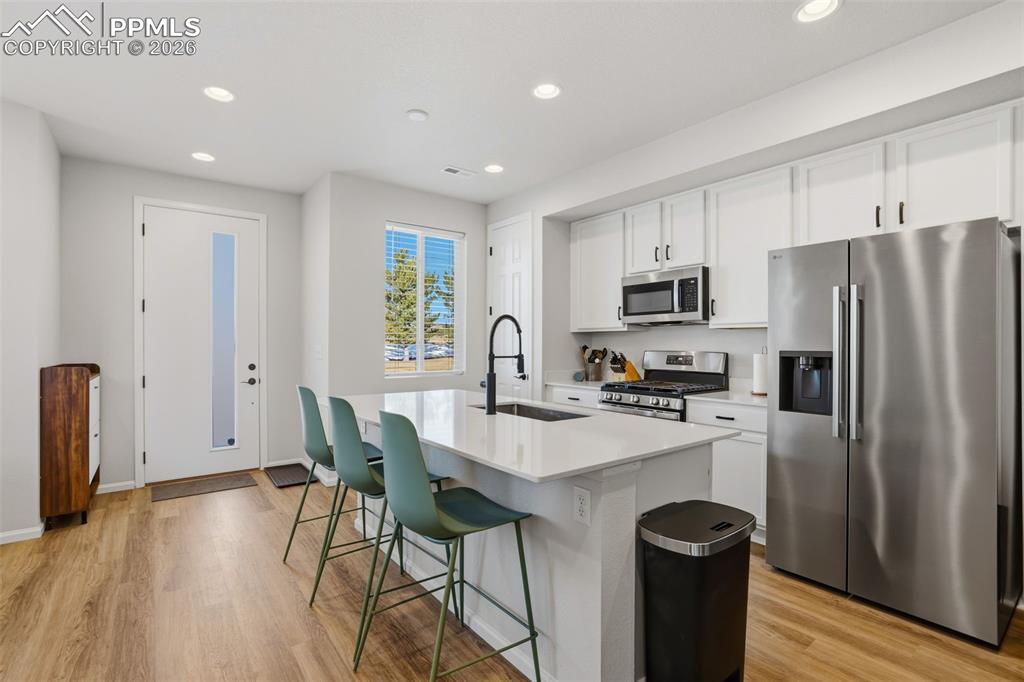 Image 6 of 28: Kitchen featuring stainless steel appliances, white cabinets, recessed ligh