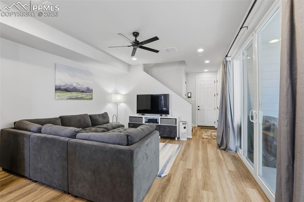 Image 9 of 28: Living area with ceiling fan, light wood finished floors, and recessed ligh