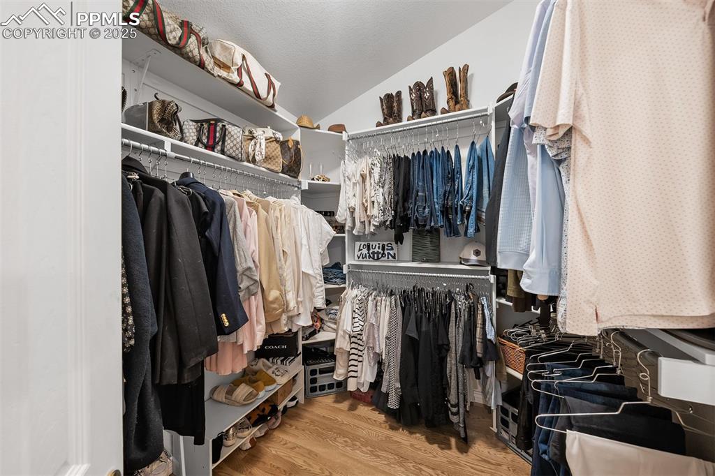 Image 13 of 30: Walk-in closet off of primary bathroom with built-in storage shelving.
