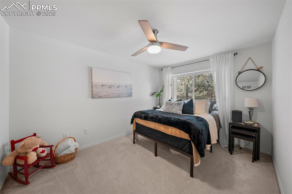 Image 18 of 30: Upper level bedroom with remote ceiling fan for comfort.