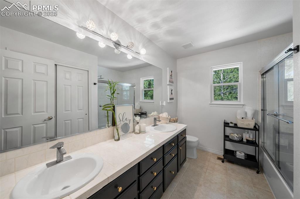 Image 19 of 30: Three quarter bath with glass enclosed step-in shower.