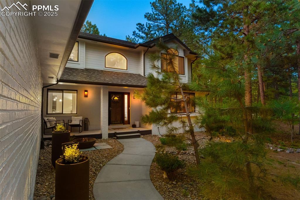 Image 2 of 30: Twilight view of front patio with water feature.