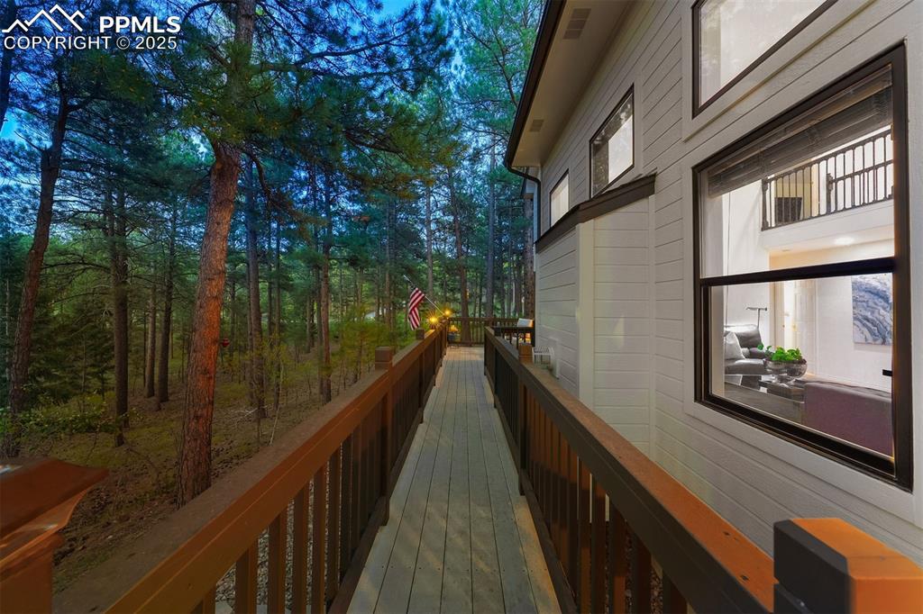 Image 25 of 30: Back full-length deck spans from kitchen to main level bedroom.