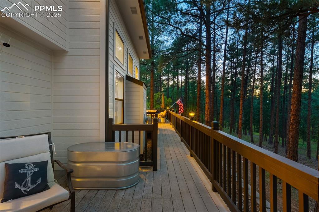 Image 26 of 30: Back full-length deck spans from kitchen to main level bedroom.