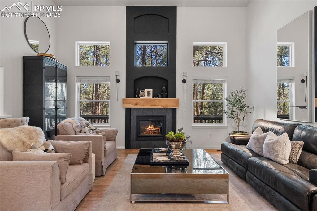 Image 5 of 30: Statement gas fireplace with tile surround and white oak mantle.