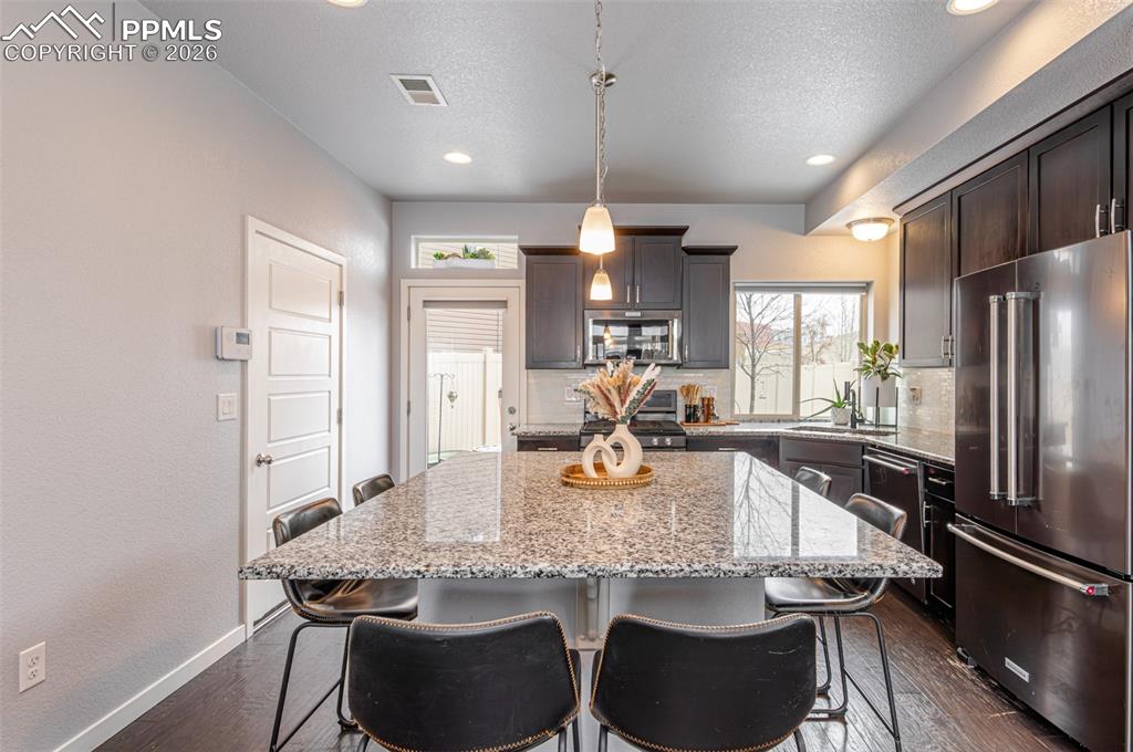 Image 11 of 29: Garage door to the left, back patio door straight ahead and large window lo