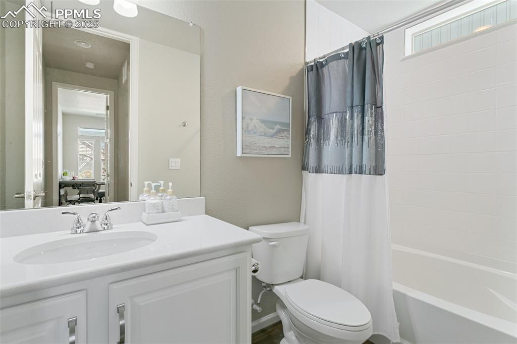 Image 21 of 35: Main-level full bathroom features quartz countertops and spacious vanity!