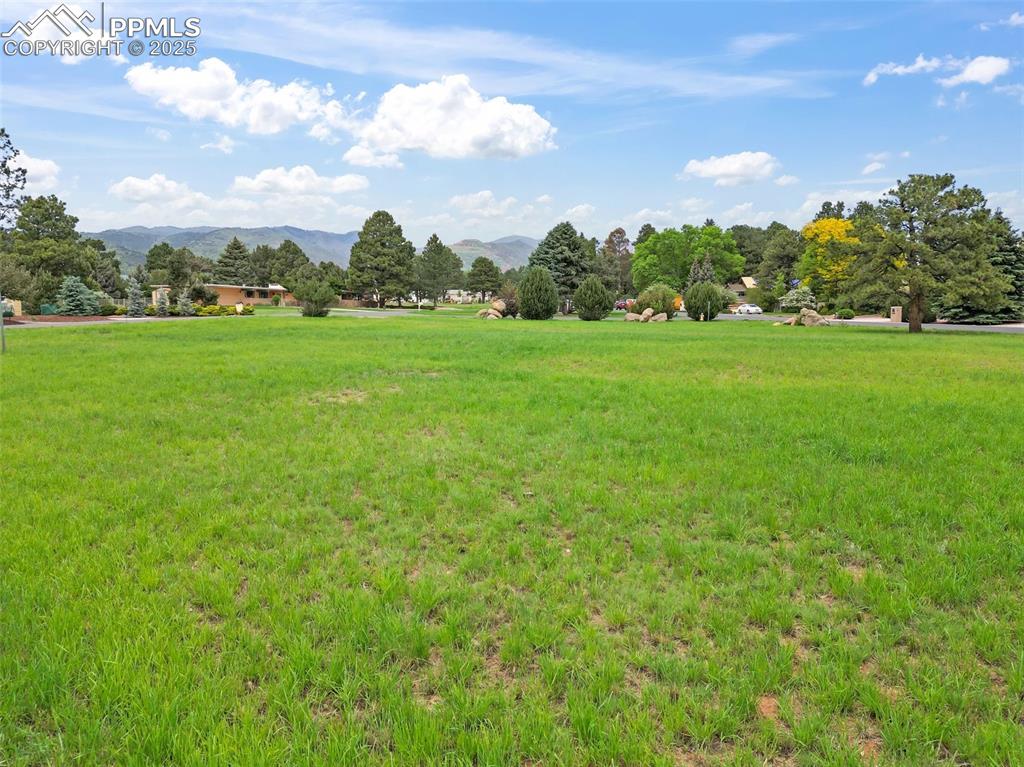 Image 16 of 24: View of community featuring a mountain view, a yard, and a view of rural / 