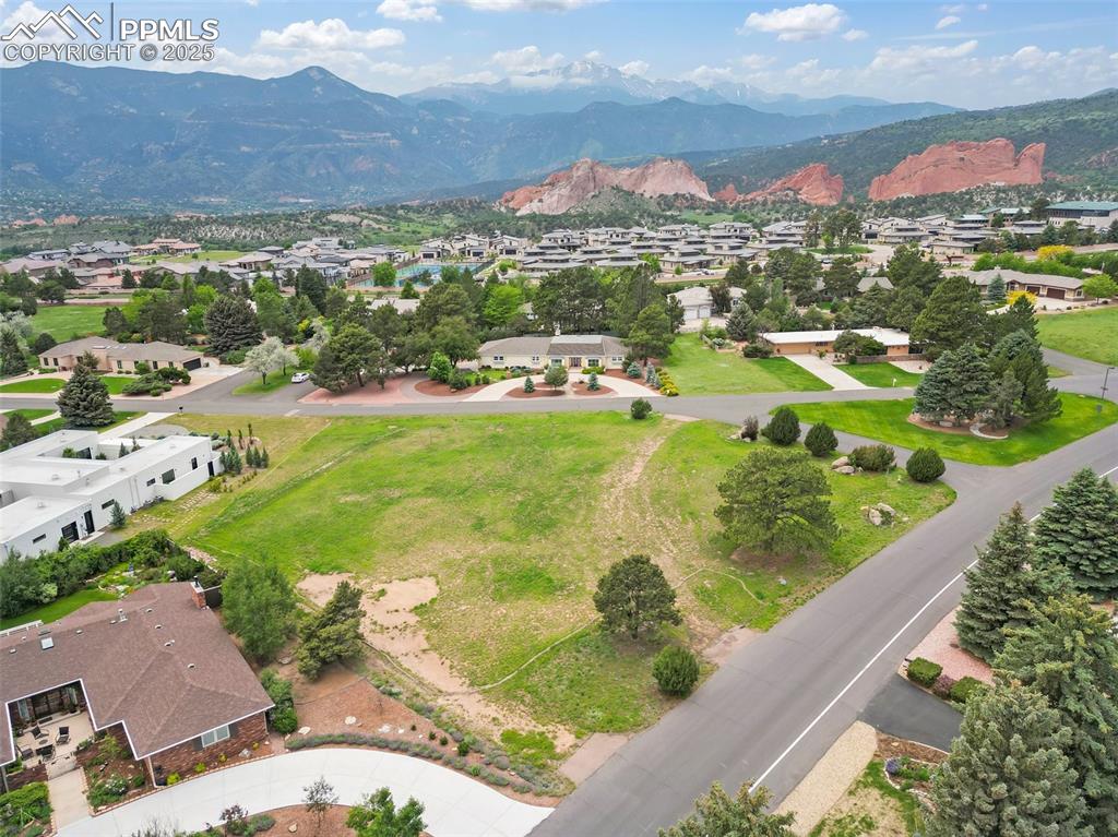 Image 2 of 24: Aerial view of residential area featuring a mountainous background