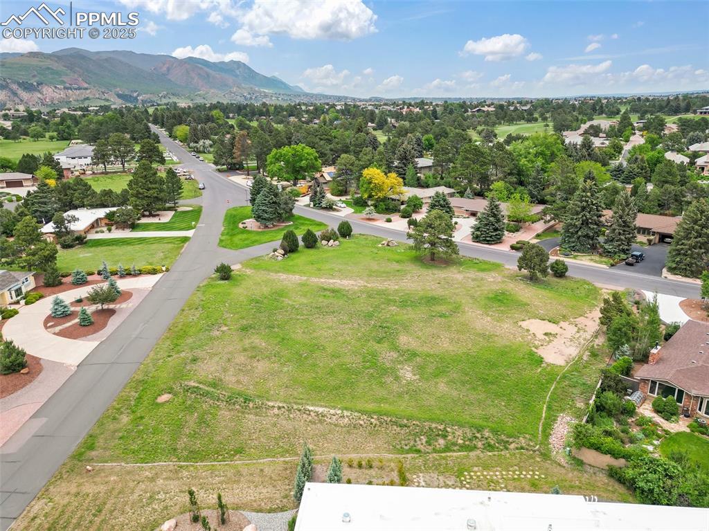 Image 4 of 24: Aerial view of residential area featuring a mountainous background