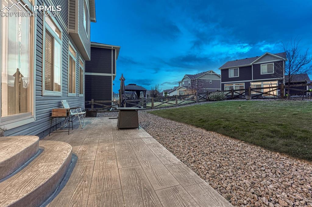 Image 17 of 50: Sunset view of composite patio and backyard.