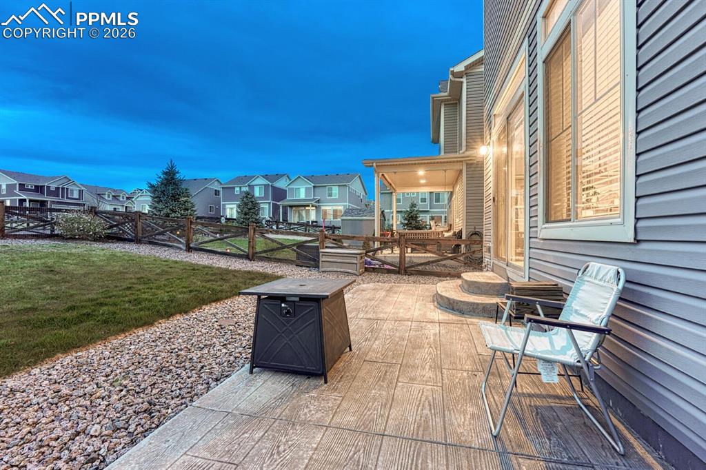 Image 18 of 50: Sunset view of backyard from the composite patio.