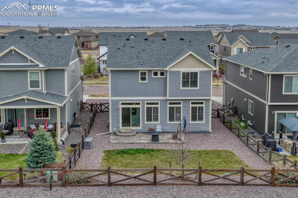 Image 34 of 50: Fenced, level backyard and rear view of home.
