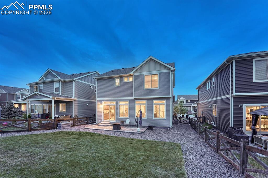 Image 37 of 50: Sunset rear view of home and backyard.