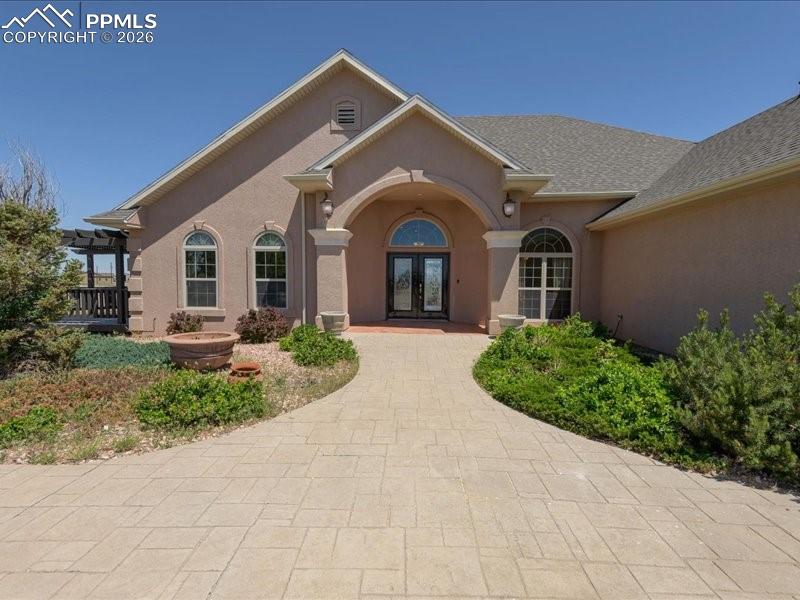 Image 1 of 48: View of exterior entry featuring french doors and stucco siding