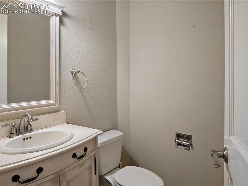 Image 12 of 48: Half bath featuring vanity and a textured wall