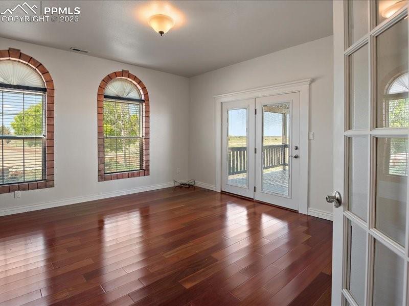 Image 13 of 48: Unfurnished room with wood finished floors, healthy amount of natural light
