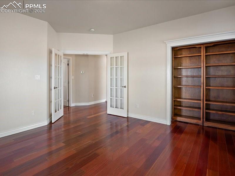 Image 14 of 48: Unfurnished bedroom featuring french doors, dark wood finished floors, and