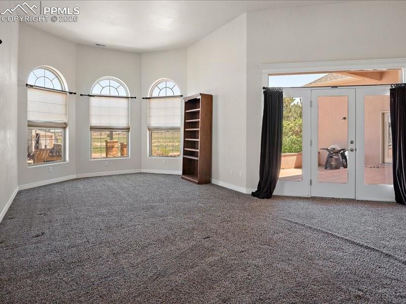 Image 18 of 48: Primary Bedroomfloors, french doors, and a high ceiling
