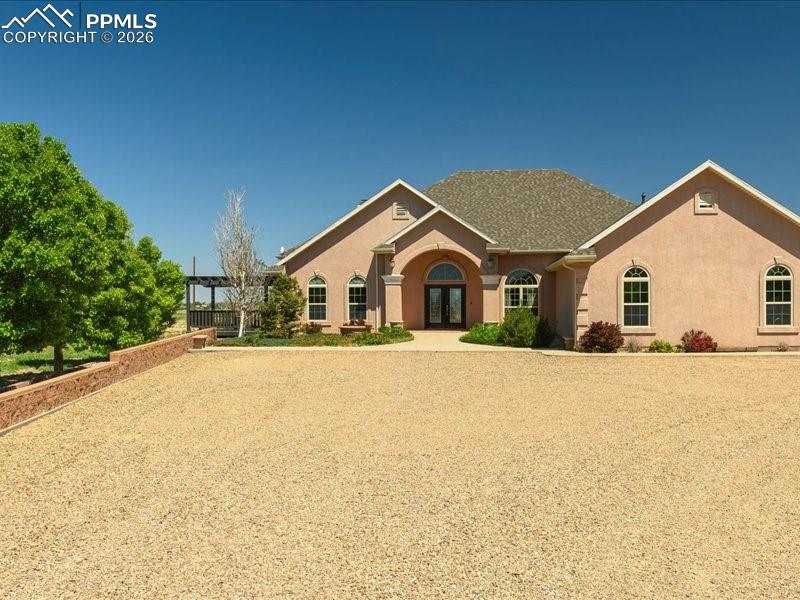 Image 2 of 48: View of front of property featuring french doors and stucco siding