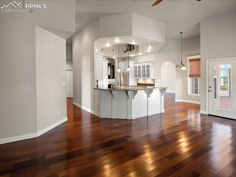 Image 21 of 48: Kitchen with a kitchen breakfast bar, white cabinetry, a ceiling fan, and h