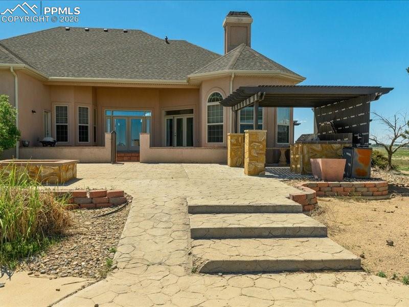Image 3 of 48: Rear view of property with a patio, french doors, roof with shingles, a chi
