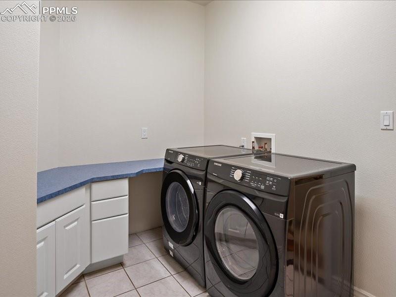 Image 33 of 48: Laundry room with light tile patterned floors and washing machine and cloth