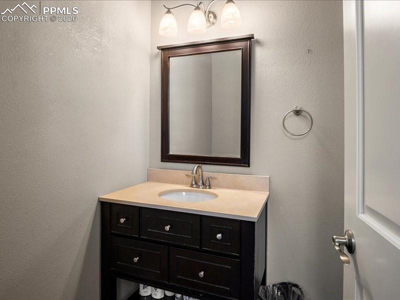 Image 38 of 48: Bathroom featuring a textured wall and vanity