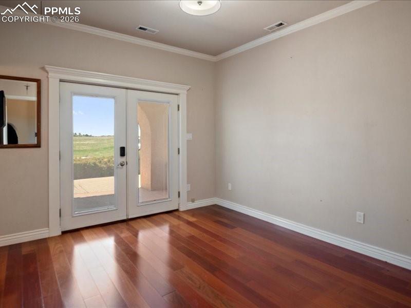 Image 40 of 48: Doorway to outside featuring french doors, crown molding, and hardwood / wo