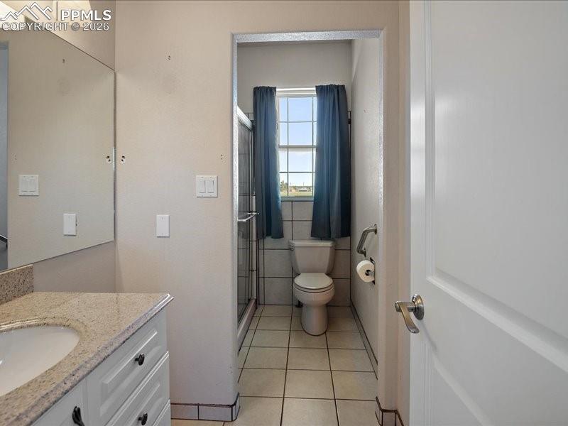 Image 41 of 48: Bathroom with vanity, a stall shower, light tile patterned flooring, and ti